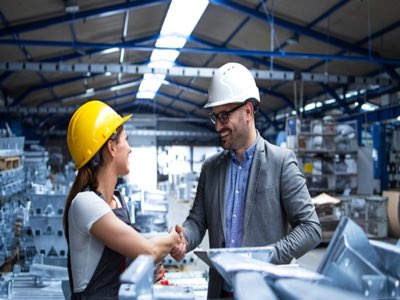 woman and man shaking hands in warehouse
