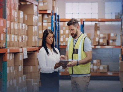 Man and woman using tablet in warehouse